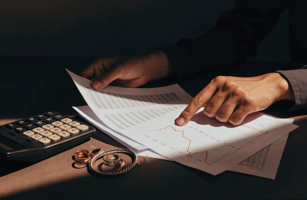 Market charts beside gold and silver jewellery